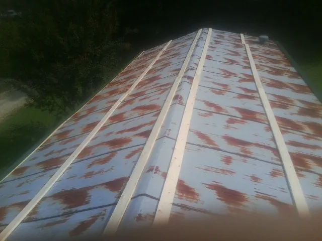 Rusted metal roof panels with new wood purlins before replacement — Storm Damage Roof Repair in Morton by Roofing Brothers